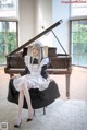 A woman sitting on top of a piano in a room.