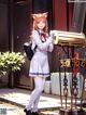 A girl in a school uniform standing next to a mailbox.