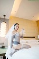 A woman in lingerie sitting on a bed in a hotel room.