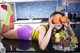 A woman laying on a kitchen counter holding two oranges.