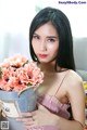 A woman holding a bucket of flowers in her hands.