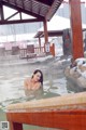 A woman in a hot tub in the middle of a snowy area.