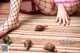 A woman in fishnet stockings is sitting on the floor with snails.