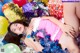 A woman in a pink dress laying on a pile of presents.