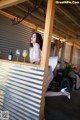 A woman leaning over a bar with a glass of orange juice.