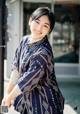 A woman in a blue kimono posing for a picture.