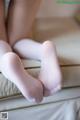 A close up of a woman's feet in white stockings.