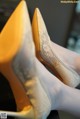 A close up of a pair of yellow shoes on a table.