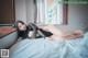 A woman laying on top of a bed in a black dress.